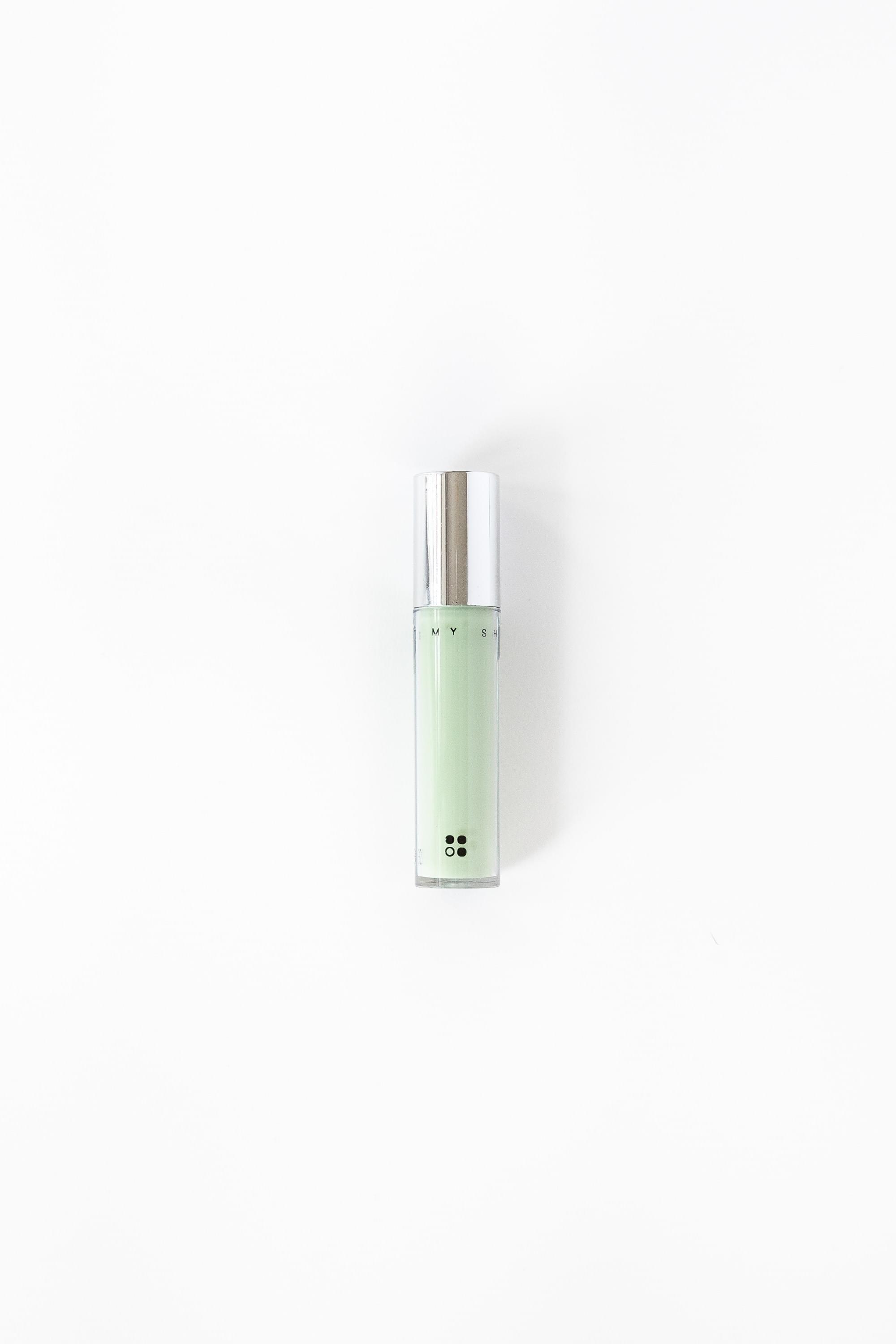 Een cilindervormig flesje met een zilveren dop, met het opschrift "Natural Concealer &