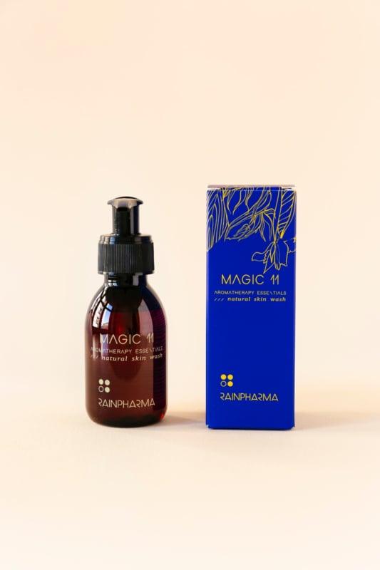 Een bruin pompflacon met het opschrift "Skin Wash Magic 11" in een blauwe verpakking van RainPharma, met natuurlijke ingrediënten, staat elegant afgebeeld op een lichte achtergrond.