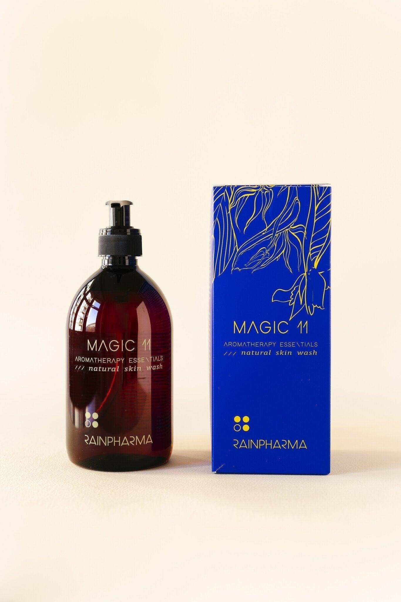 RainPharma Skin Wash Magic 11, een natuurlijke aromatherapie-essential met plantaardige douchegel, wordt geleverd in een donkere fles en een blauwe doos met een bloemenmotief.