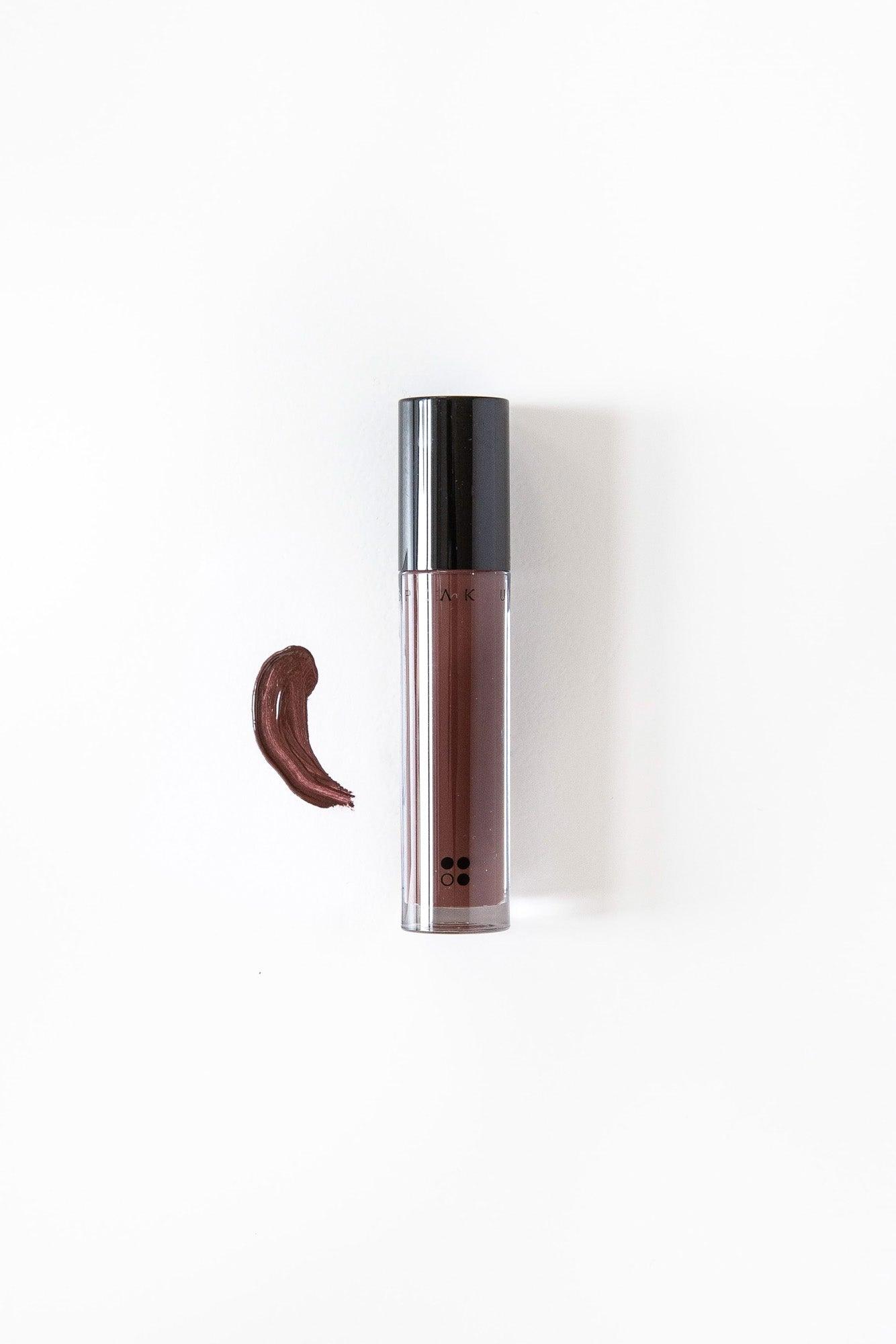 Speak Up - Natural Lip Tint van RainPharma wordt geleverd in een donkere tube met daarbij een swatch van dezelfde rijk gepigmenteerde kleur op een witte achtergrond.