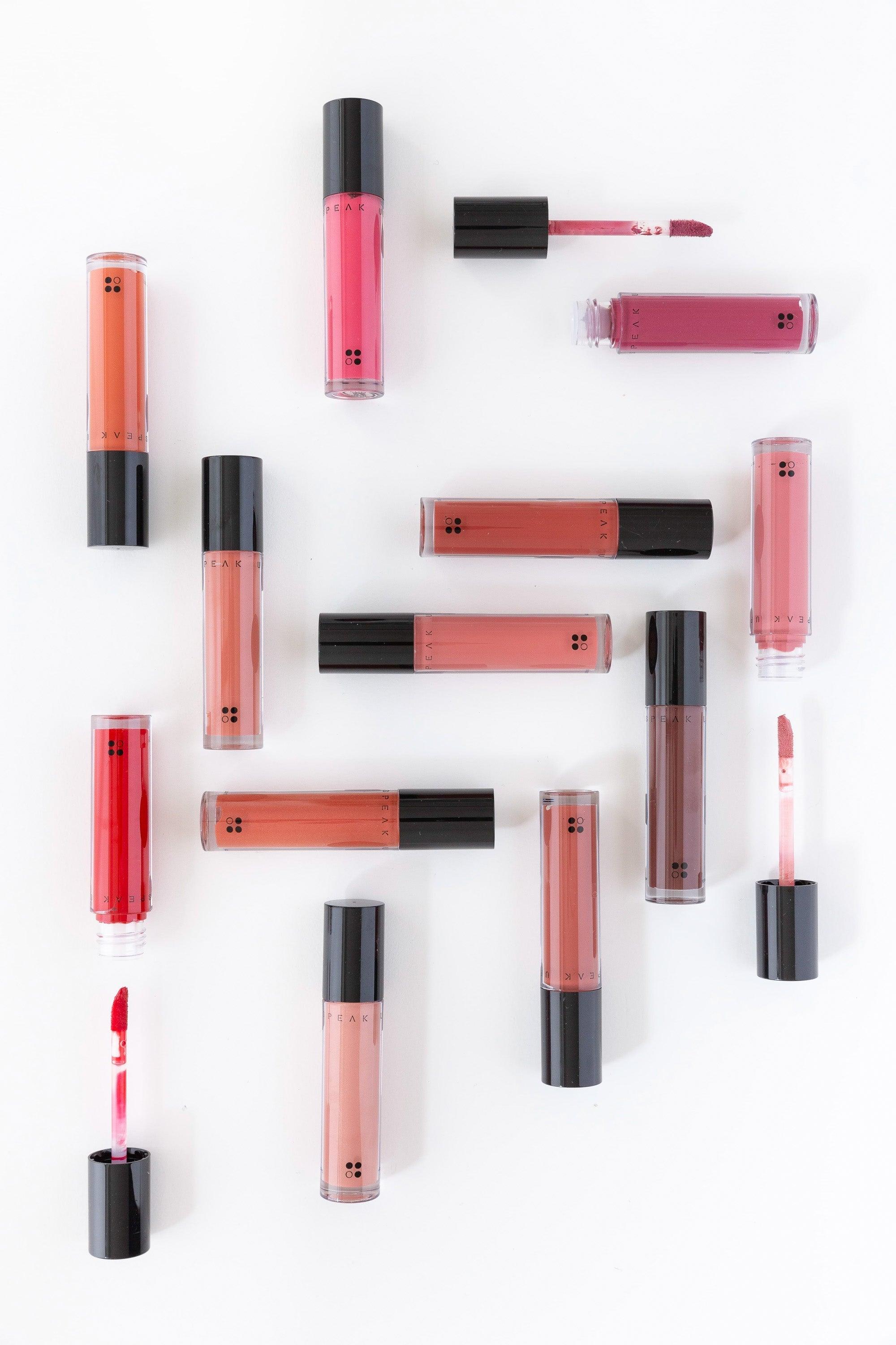 Verschillende tinten Speak Up - Natural Lip Tint van RainPharma zijn verspreid over een witte achtergrond, elk gecombineerd met een chique lipgloss applicator.
