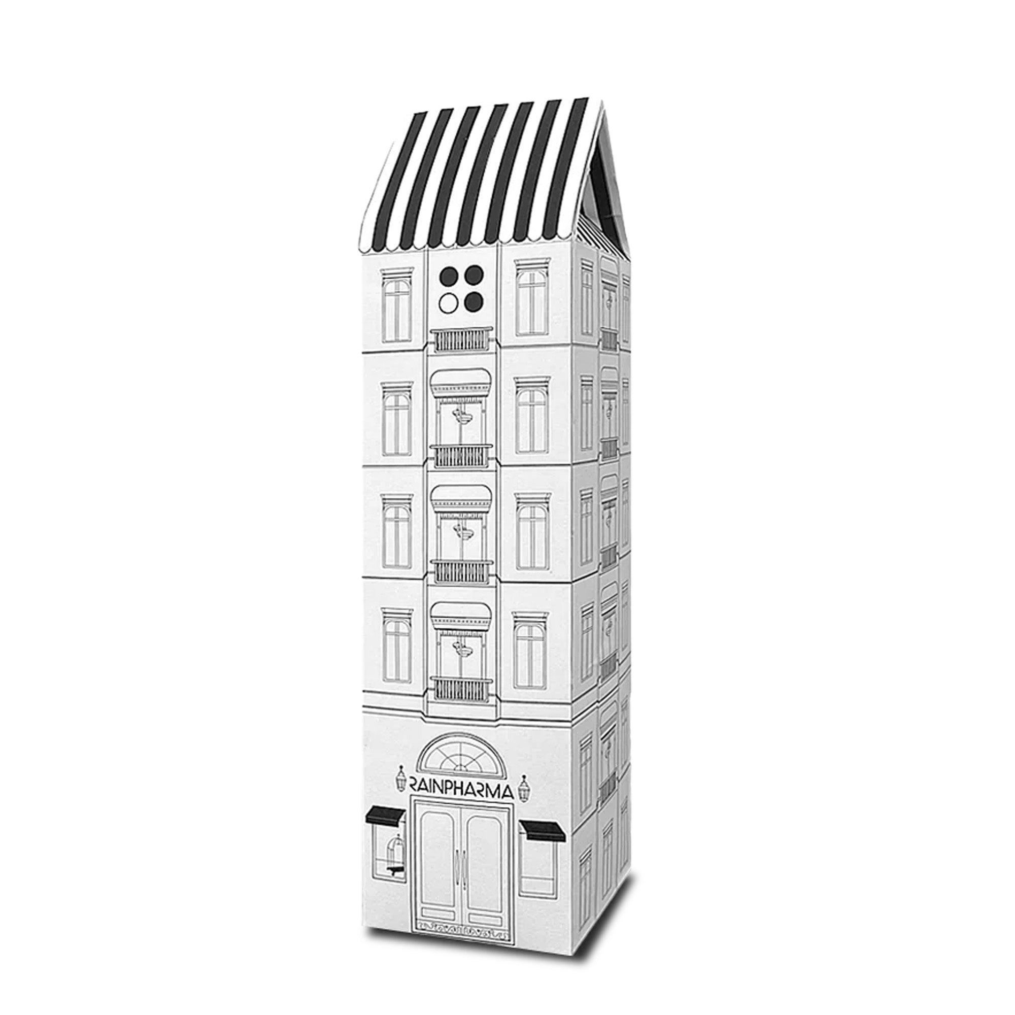 Illustratie van een hoog, smal gebouw met het label "RainPharma" boven de deur. Ramen en een gestreept dak sieren het. Een bord adverteert met de Hotel - Budget Gift set, met Skin Wash Lemongrass & Sacred Seven Body Repair Oil 60 ml erin.