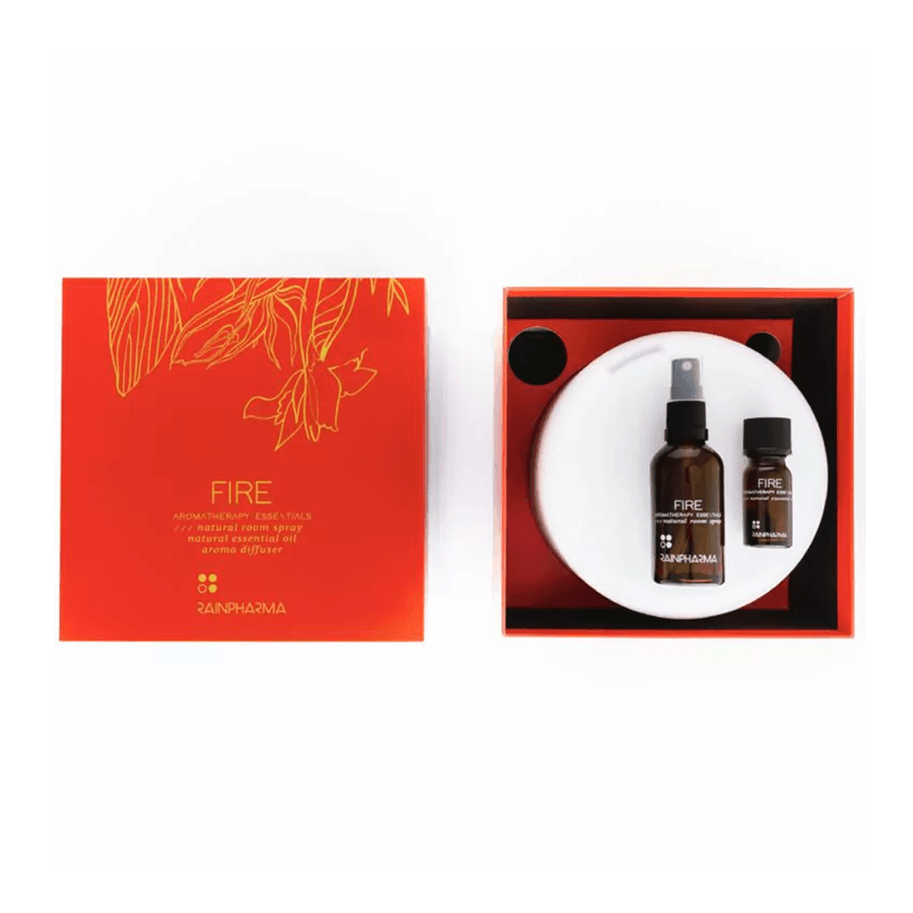 De Aroma Diffuser Geschenkbox - Fire van RainPharma, een rode doos met het opschrift "FIRE", bevat aromatische olieproducten, waaronder een kamerverstuiver en etherische olie, stijlvol gerangschikt op een wit oppervlak.