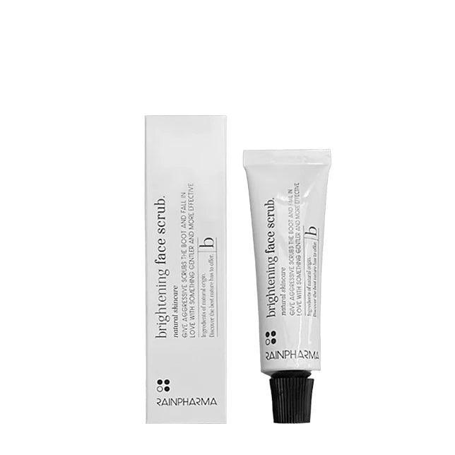 Een tube en doos RainPharma Face Scrub (Brightening Face Scrub) van RainPharma, een natuurlijke scrub voor een zachte huid, staan rechtop tegen een effen witte achtergrond.