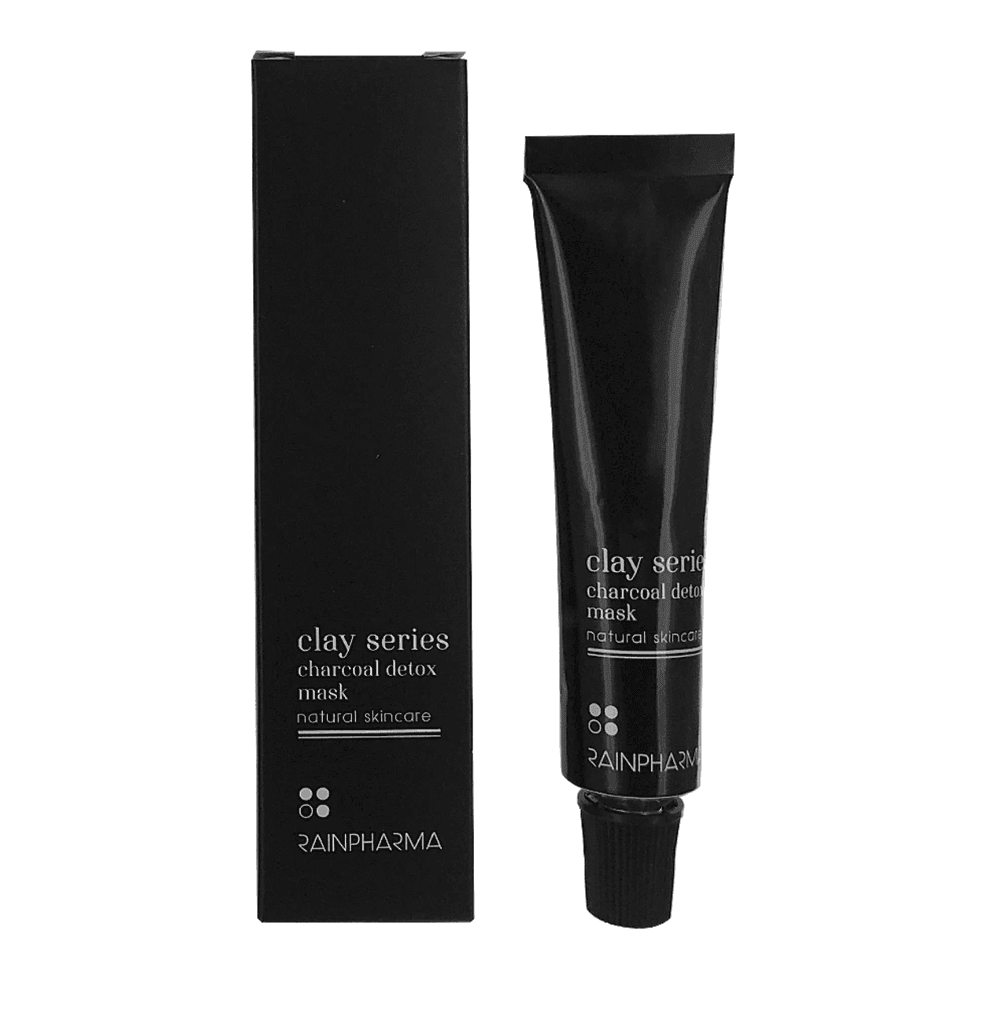 Een zwarte tube en doos met de tekst "Charcoal (Detox) Mask - Zuiverend masker elk huidtype" van RainPharma staan rechtop op een witte achtergrond.