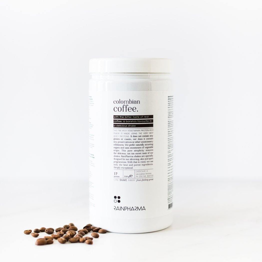 Een witte container met het opschrift &quot;Colombiaanse Coffee Shake&quot; van Rainpharma, tegen een effen witte achtergrond, met enkele koffiebonen verspreid aan de rechterkant.