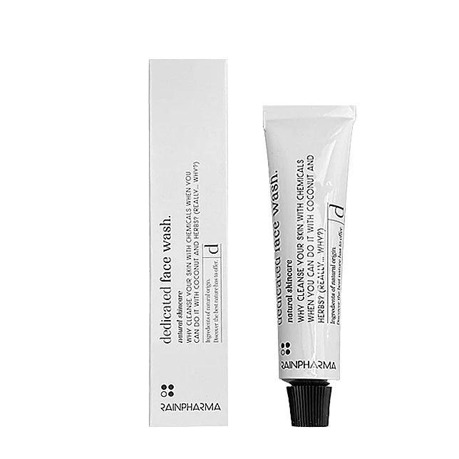 Een zilveren tube RainPharma Dedicated Face Wash 200 ml, een natuurlijke reiniger met citrusaroma, staat afgebeeld naast de bijpassende rechthoekige doos. Op beide verpakkingen staan de productdetails in zwarte letters.