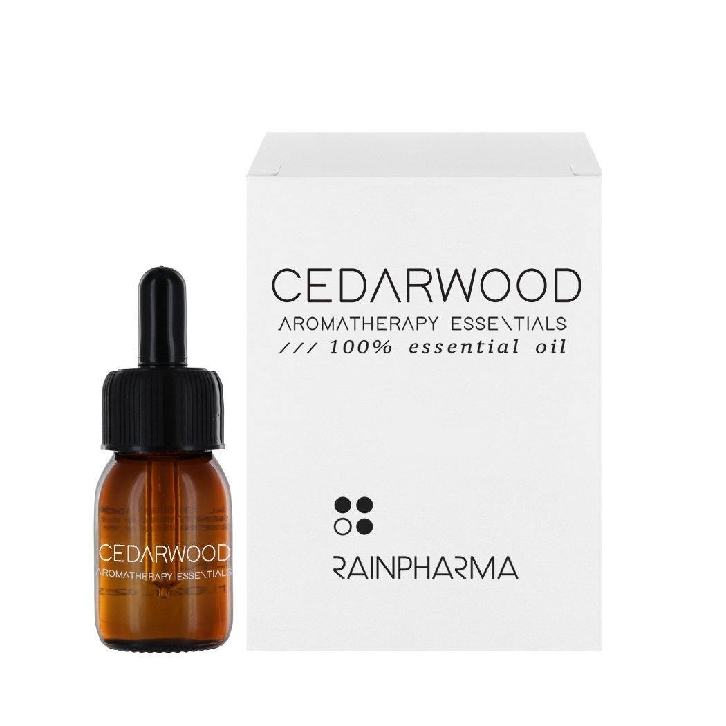 Een bruine glazen druppelflacon van RainPharma essentiële olie cederhout (ceder geur) wordt getoond naast een wit doosje, perfect voor je aroma diffuser.