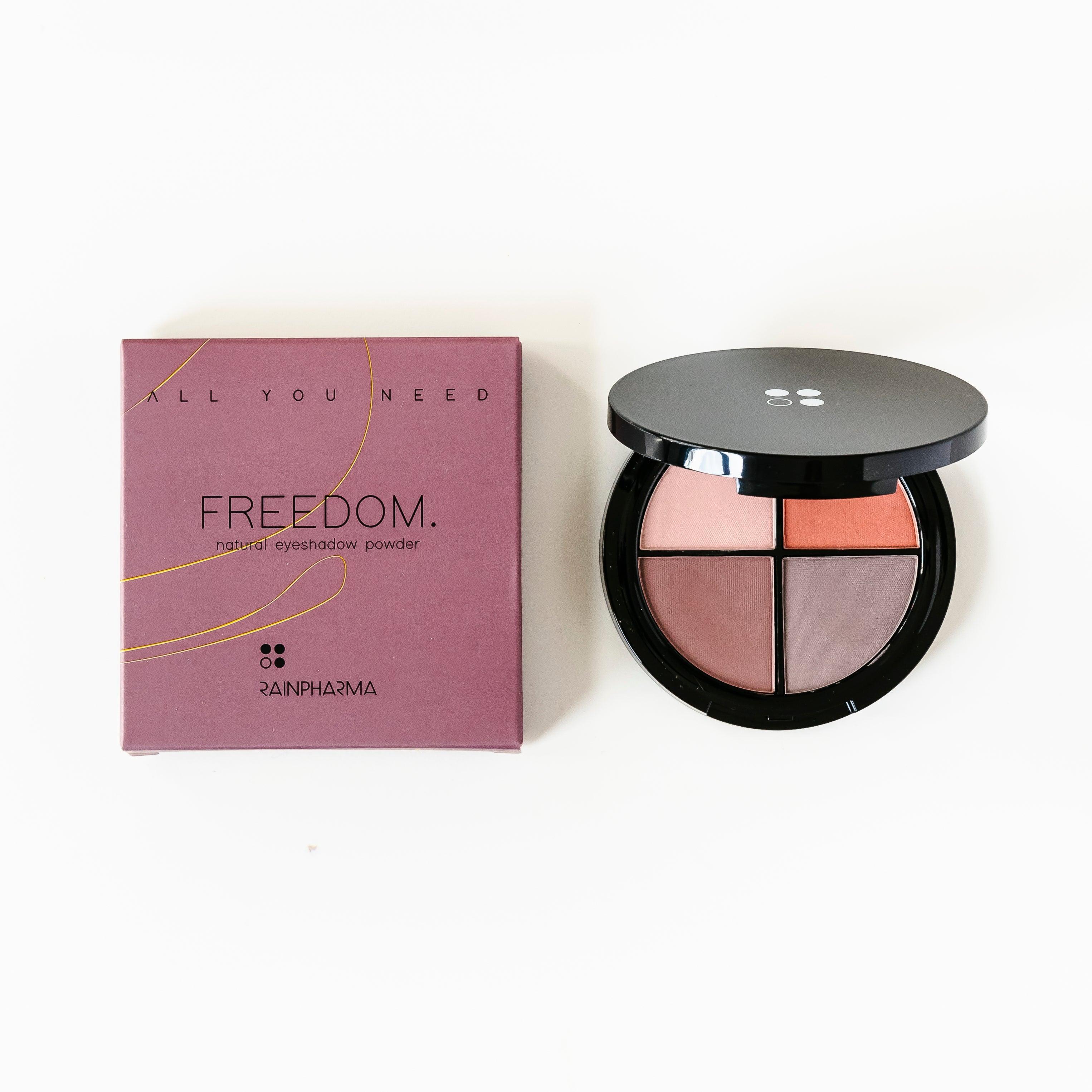 Een cadeaubon met het opschrift "Cadeaubon Make-up verwenmoment voor twee" van Puur Living ligt naast een open make-updoosje met daarin vier tinten natuurlijke make-up.