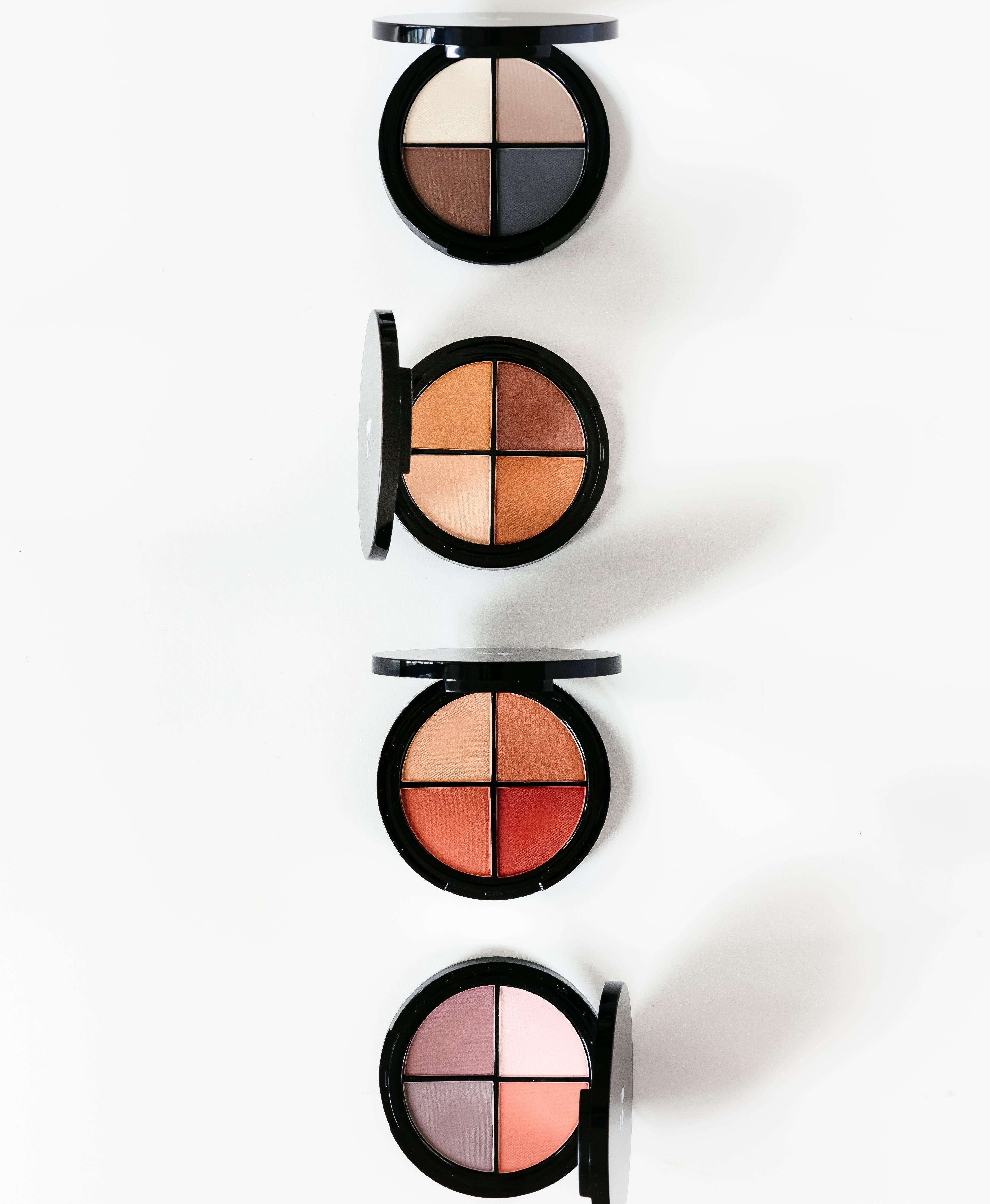 Vier ronde Puur Living make-up paletten met elk vier kleurtinten van neutraal tot warme en roze tinten, verticaal gerangschikt op een witte achtergrond - perfect als Cadeaubon Make-up verwenmoment voor twee.