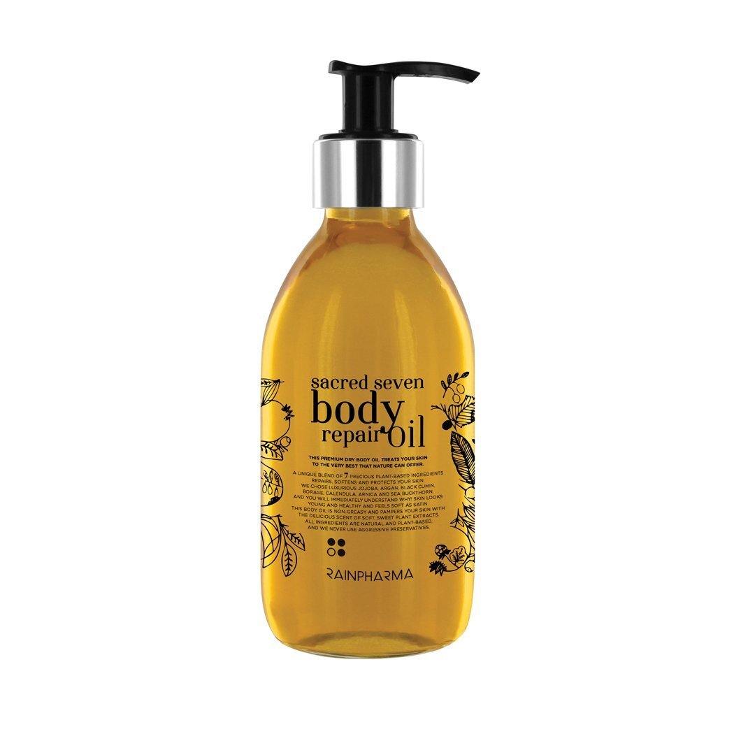 Een flesje Sacred Seven Body Repair Oil van RainPharma heeft een zwarte pompdispenser en een bloemenetiket, en is gemaakt van plantaardige ingrediënten.