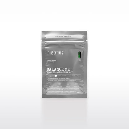 Een grijs pakje met de tekst „Insentials Balance Me – Hormonale Balans &amp; Menopauze Support” staat rechtop, met daarop een afbeelding van een groene capsule, met rhodiola en maca ter ondersteuning van de hormonale regulatie.