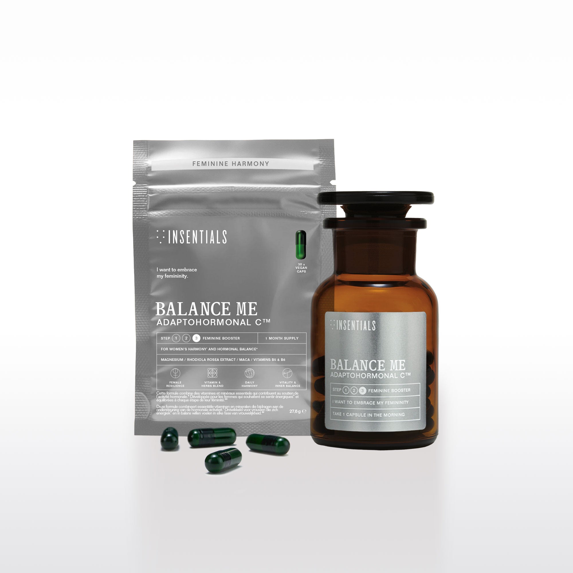 Er is een bruine fles en een grijs zakje te zien met het opschrift „Balance Me – Hormonale Balans &amp; Menopauze Support” van Insentials, met daarin groene capsules die ingrediënten bevatten zoals rhodiola en maca voor hormonale regulatie.