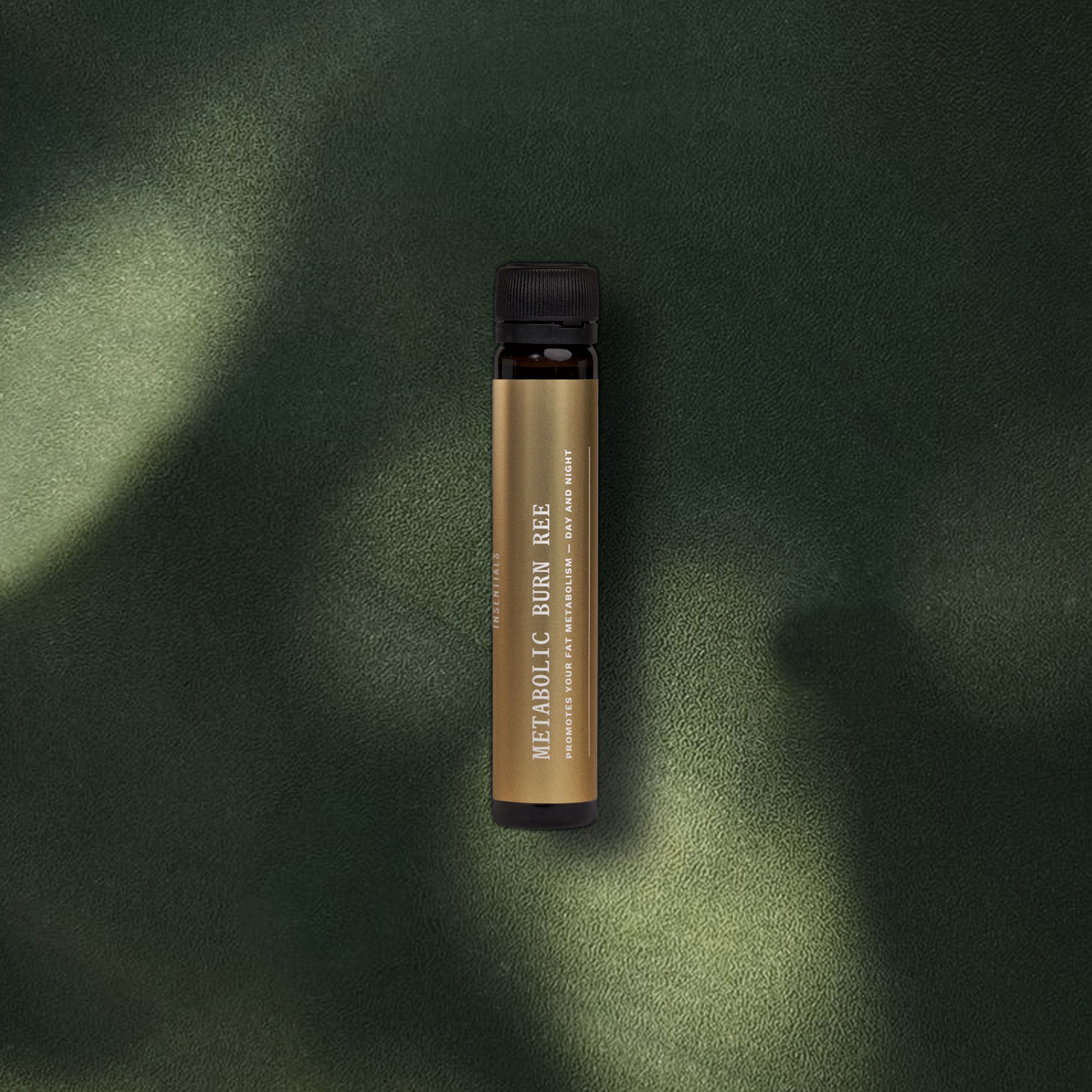 Een klein, donkerbruin buisje met een zwarte dop waarop „Metabolic Burn REE – Ondersteunt Metabolisme in Rust” staat vermeld, van Insentials – een krachtig supplement dat is ontwikkeld om je ruststofwisseling te ondersteunen – ligt op een donkergroen oppervlak met structuur.