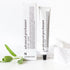 Naast de doos ligt een tube met het opschrift "Advanced Precleanser - gelaatsreiniger op oliebasis" van RainPharma, met een takje groene blaadjes en een witte doek voor een natuurlijke uitstraling.