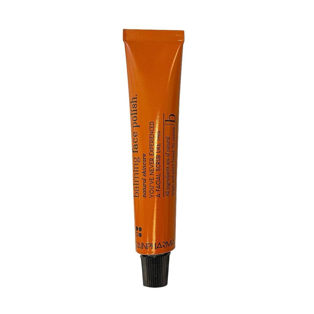 Een oranje tube RainPharma Balming Face Polish (alle huidtypes) met zwarte tekst en een zwarte schroefdop, ideaal voor gelaatsverzorging, is afgebeeld tegen een witte achtergrond.