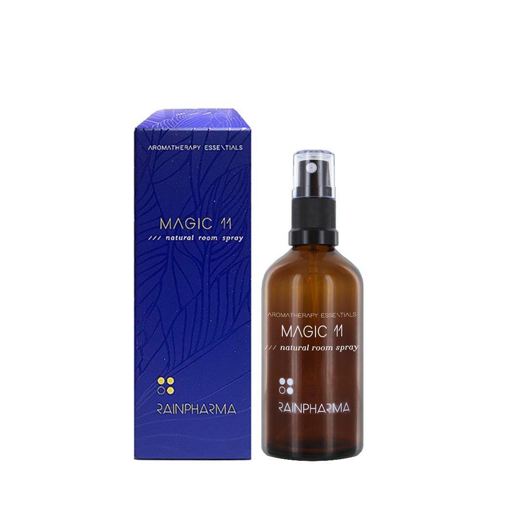 Een bruine sprayfles met het label "Natural Room Spray - Magic 11" met essentiële oliën staat naast de paarse doos met het RainPharma-logo.