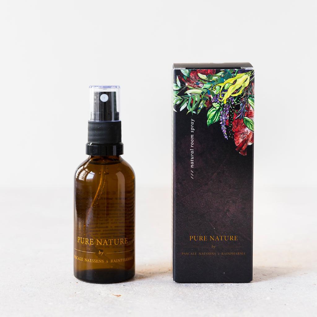 Een bruine 50ml "Natural Room Spray - Pure Nature by Pascale Naessens" van RainPharma staat naast het bijpassende geïllustreerde doosje en roept de natuurlijke essentie op van een kamerverspreider met pure essentiële oliën.