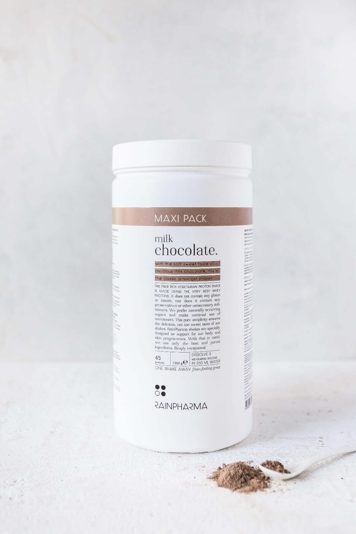 Een witte container met het opschrift &quot;RainPharma Shake Milk Chocolate XL&quot; staat er trots bij, en biedt een rijk eiwitrijk tussendoortje met gedetailleerde voedingsinformatie, vergezeld van een klein hoopje chocoladepoeder. Perfect voor degenen die genieten van Rainpharma shakes.