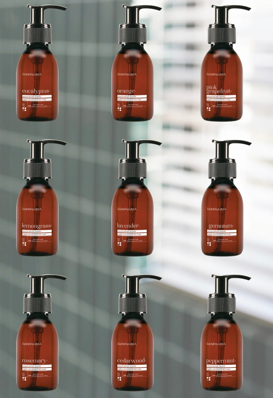 Negen bruine pompflacons van RainPharma’s Skin Washes - Belevingsset - 9 geuren, gemaakt met plantaardige ingrediënten, zijn gerangschikt in twee verticale kolommen en gelabeld met verschillende geuren tegen een wazige achtergrond.