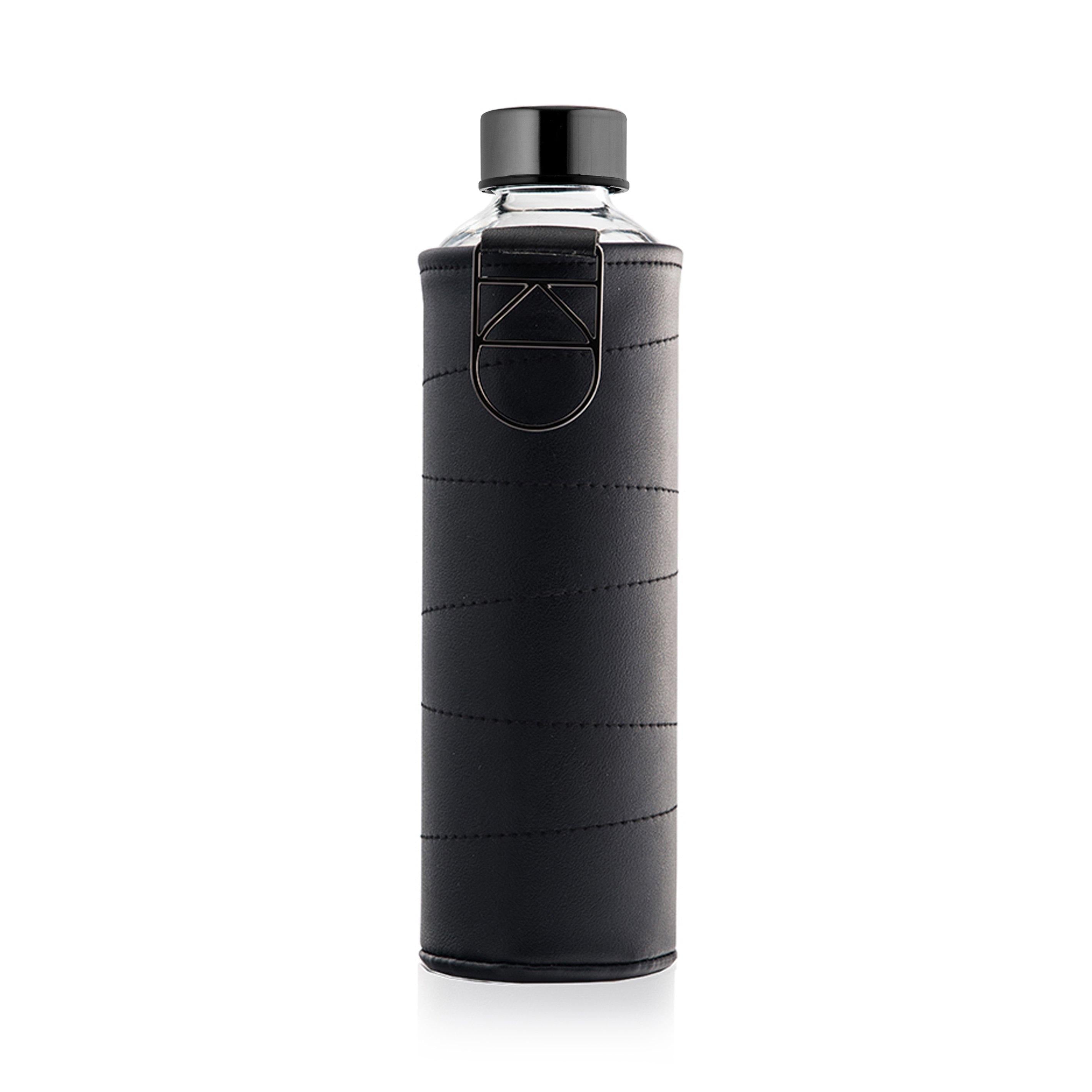 De Equa Mismatch Leather Graphite waterfles van Equa is een heldere borosilicaatglas fles met een zwarte dop, verpakt in een zwart gestikte hoes met een metalen ring en geometrisch accent voor een stijlvolle, duurzame en milieuvriendelijke optie.