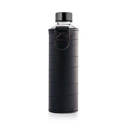 De Equa Mismatch Leather Graphite waterfles van Equa is een heldere borosilicaatglas fles met een zwarte dop, verpakt in een zwart gestikte hoes met een metalen ring en geometrisch accent voor een stijlvolle, duurzame en milieuvriendelijke optie.