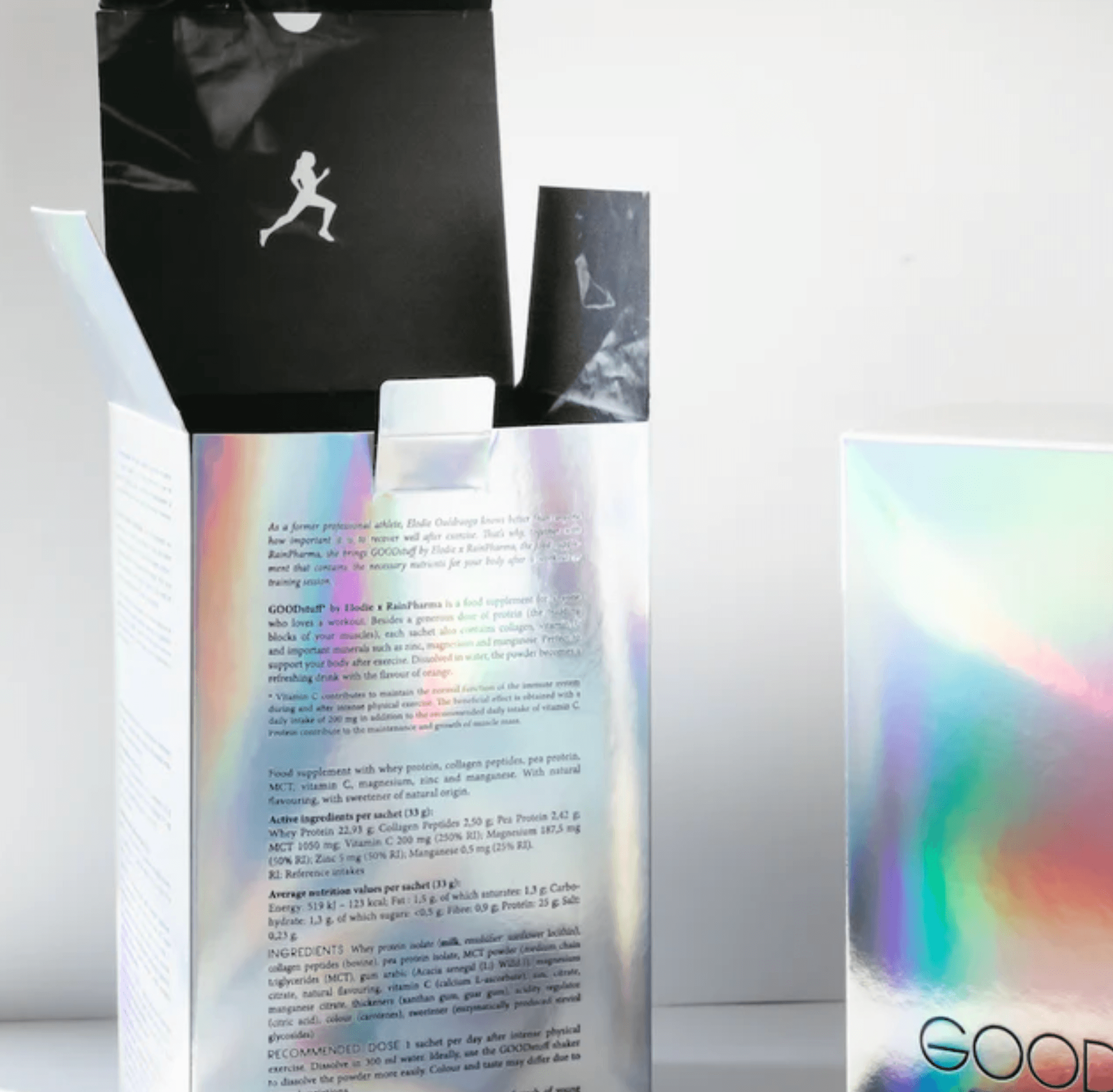 Esthetisch beeld met een assortiment GOODstuff by Elodie x Rainpharma productverpakkingen met holografische en monochrome ontwerpen, onthullende texturen en merkdetails, inclusief collageensupplementen.